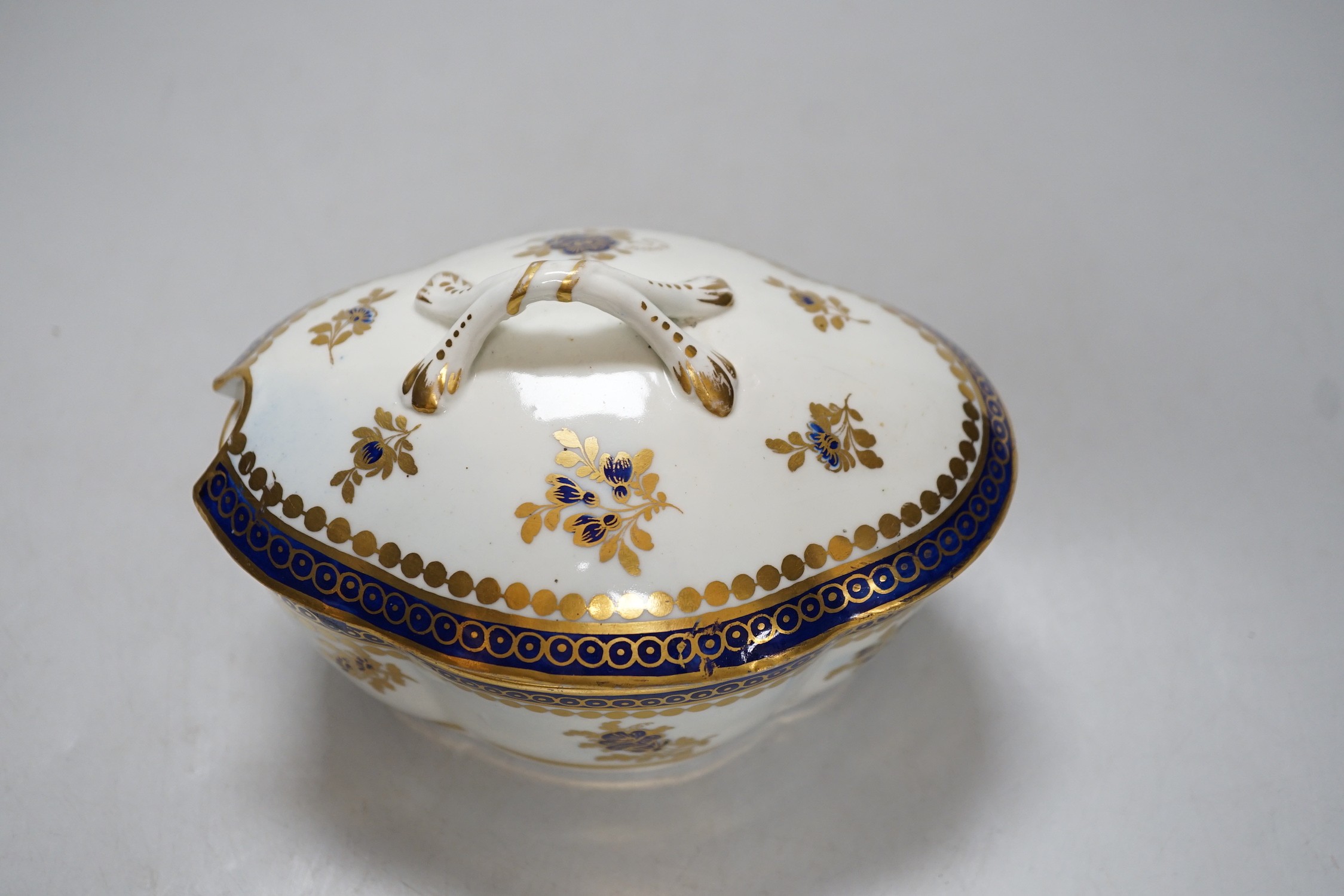 An 18th century Caughley tureen cover and stand with blue and gilt decoration, stand mis-fired to border, S mark to stand and base. 15cm wide